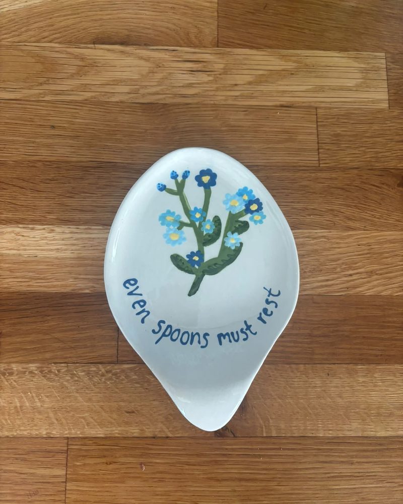 Spoon rest painted with forget-me-nots and the words even spoons must rest